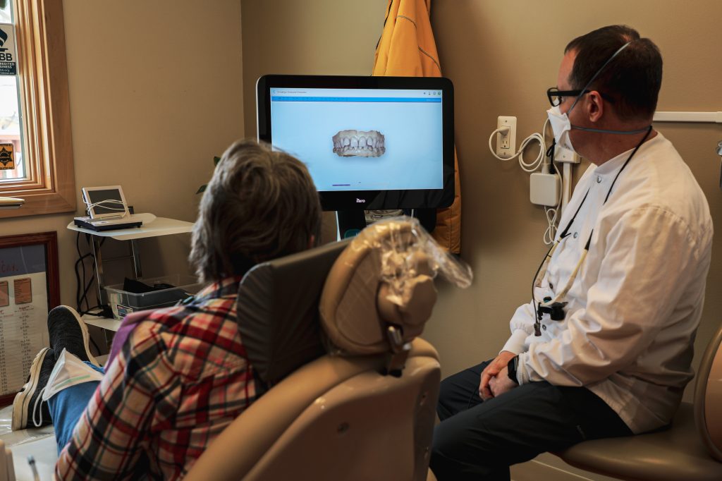 Patient looking at dental images on screen with a team member at David Schmidt, DDS