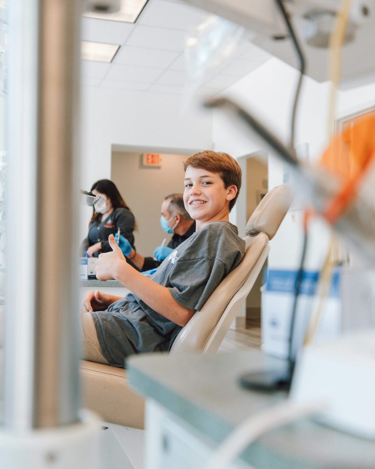Teen patient giving a thumbs up in the dental chair